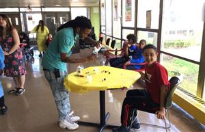 Paraprofessional staff helping a student in completing their planting project